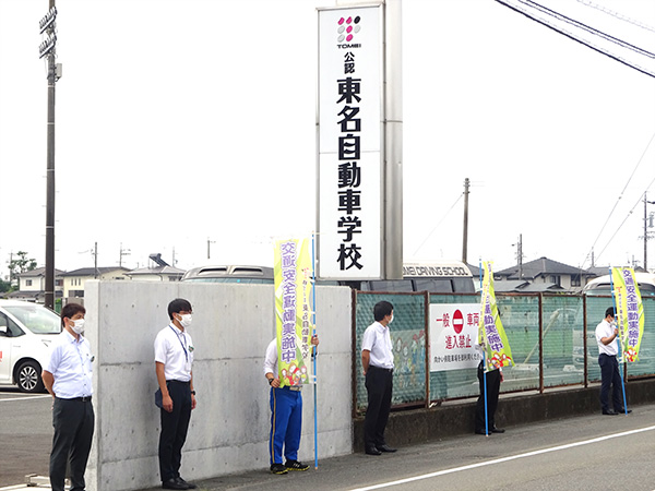 正門の看板前『夏の交通安全県民運動』の交通安全活動【写真】